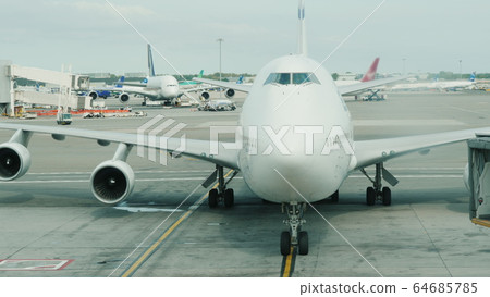 The arrival of a giant two-story airliner to the terminal. Slowly approaching the hub The arrival of a giant two-story airliner to the terminal. Slowly approaching the hub 64685785