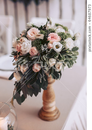 Bouquet of roses pink and white on the wedding table in a wooden vase Bouquet of roses pink and white on the wedding table in a wooden vase 64687973