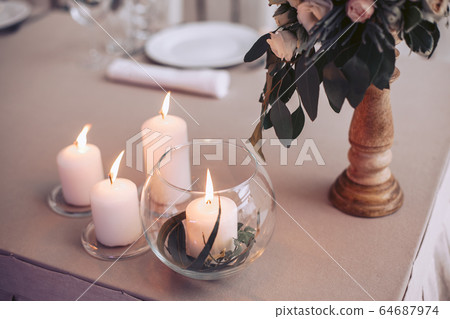 Wedding table with candles and a bouquet of flowers Wedding table with candles and a bouquet of flowers 64687974