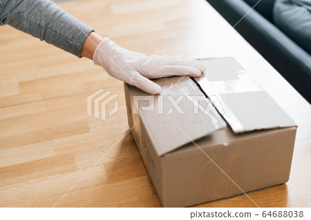 Close up of woman hands in gloves packing box with fresh fruits and vegetables. Online supermarket Close up of woman hands in gloves packing box with fresh fruits and vegetables. Online supermarket 64688038