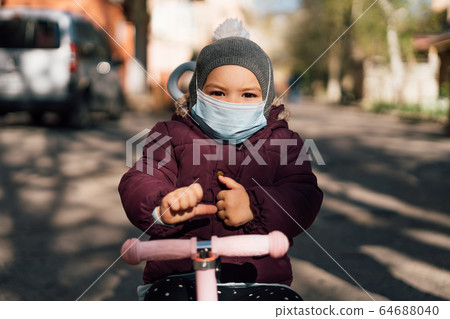 Toddler child wearing face medical mask outdoors in cold weather. air pollution pm2.5 or covid-19 Toddler child wearing face medical mask outdoors in cold weather. air pollution pm2.5 or covid-19 64688040