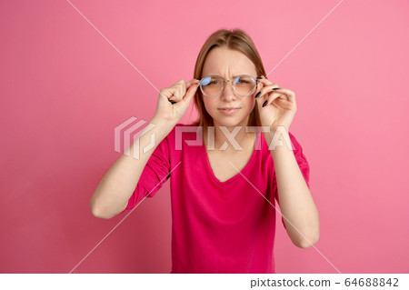 Caucasian young woman's monochrome portrait on pink studio background, emotinal and beautiful Caucasian young woman's monochrome portrait on pink studio background, emotinal and beautiful 64688842