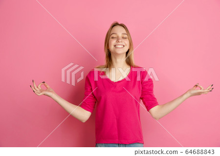 Caucasian young woman's monochrome portrait on pink studio background, emotinal and beautiful Caucasian young woman's monochrome portrait on pink studio background, emotinal and beautiful 64688843