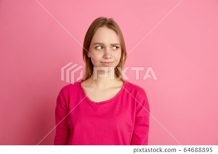 Caucasian young woman's monochrome portrait on pink studio background, emotinal and beautiful Caucasian young woman's monochrome portrait on pink studio background, emotinal and beautiful 64688895