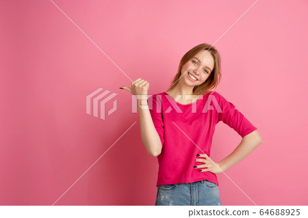 Caucasian young woman's monochrome portrait on pink studio background, emotinal and beautiful Caucasian young woman's monochrome portrait on pink studio background, emotinal and beautiful 64688925