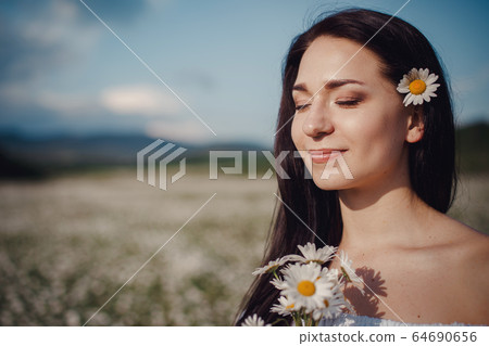 Beautiful brunette woman is enjoying spring in a 64690656