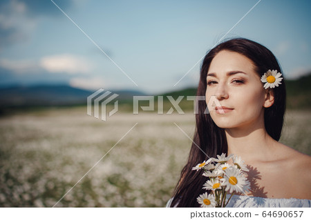 Beautiful brunette woman is enjoying spring in a Beautiful brunette woman is enjoying spring in a 64690657