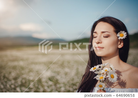 Beautiful brunette woman is enjoying spring in a Beautiful brunette woman is enjoying spring in a 64690658