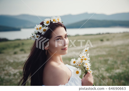 Beautiful brunette woman is enjoying spring in a Beautiful brunette woman is enjoying spring in a 64690663