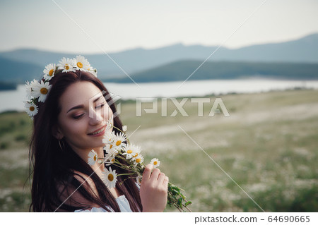 Beautiful brunette woman is enjoying spring in a Beautiful brunette woman is enjoying spring in a 64690665