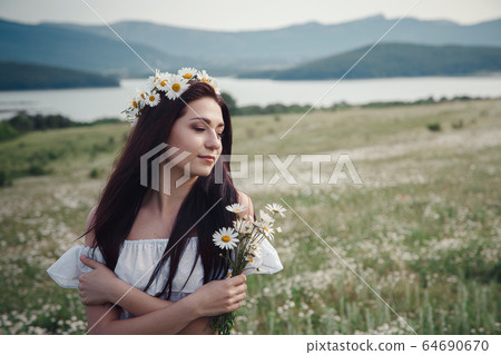 Beautiful brunette woman is enjoying spring in a Beautiful brunette woman is enjoying spring in a 64690670