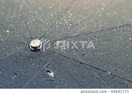 Close-up detail texture surface of big black wet open umbrella covered with water drops after pouring shower rain on spring or autumn rainy day. Seasonal weather background Close-up detail texture surface of big black wet open umbrella covered with water drops after pouring shower rain on spring or autumn rainy day. Seasonal weather background 64691173