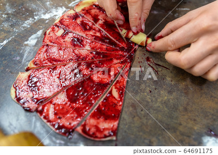 Grandmother making handmade tasty butter rolling cookies with fruit and berry jam on oven tray before baking at kitchen indoor. Rolled spin homemade healthy pastry preparing Grandmother making handmade tasty butter rolling cookies with fruit and berry jam on oven tray before baking at kitchen indoor. Rolled spin homemade healthy pastry preparing 64691175