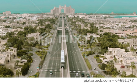 Low altitude aerial view of the Palm Jumeirah island monorail train in Dubai, UAE Low altitude aerial view of the Palm Jumeirah island monorail train in Dubai, UAE 64691177