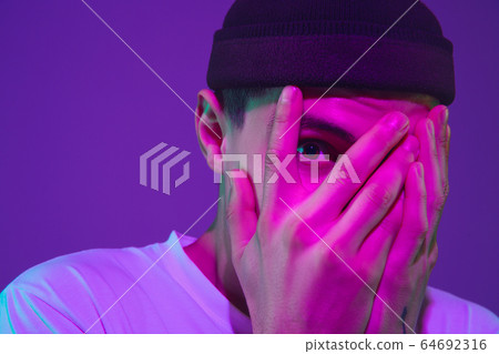 Caucasian man's portrait isolated on purple studio background in neon light Caucasian man's portrait isolated on purple studio background in neon light 64692316