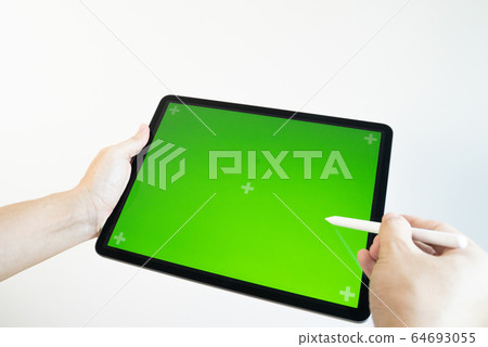 Hand draws a pencil on a tablet with a chromakey on the screen. 64693055