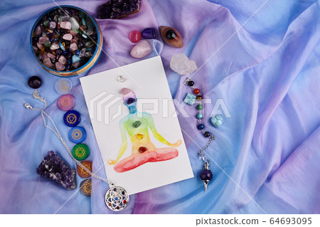 Natural crystals and pendulum on pastel silk background. Reiki background with card. Natural crystals and pendulum on pastel silk background. Reiki background with card. 64693095