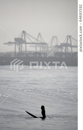 High contrast of unrecognizable surfer woman waiting 64693592