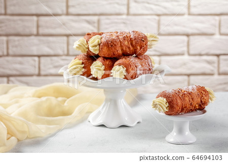 Austrian schaumrollen on a dessert stand, close-up 64694103