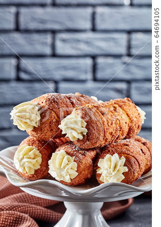 Kremrole with cream on a white dessert stand 64694105