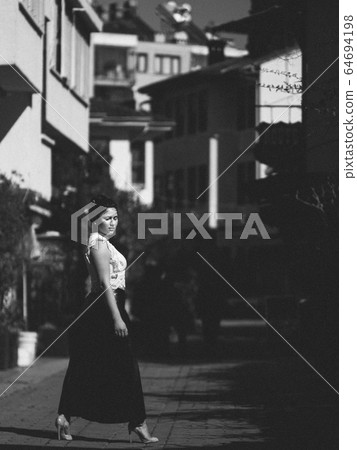 Woman standing on the street Woman standing on the street 64694198