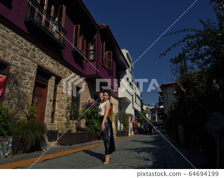 Woman standing on the street Woman standing on the street 64694199