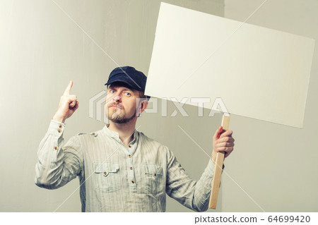 Work young man points finger on a blank banner Work young man points finger on a blank banner 64699420