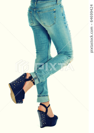 girl in jeans and high heels with studs 64699424