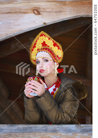 Russian girl in a kokoshnik drinking tea 64701008