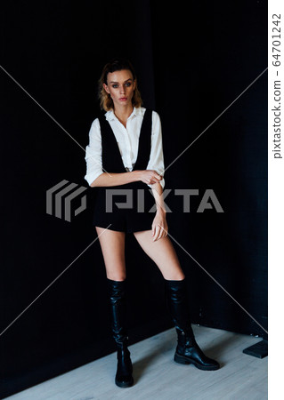 Portrait of a beautiful young fashionable blonde woman in a shirt and black shorts Portrait of a beautiful young fashionable blonde woman in a shirt and black shorts 64701242