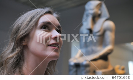 The girl examines the exhibits in the museum. The girl examines the exhibits in the museum. 64701668