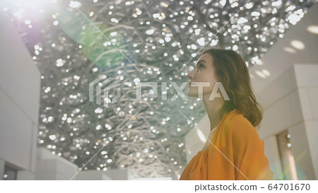 Girl enjoys views of the Louvre Hall in Abu Dhabi. Girl enjoys views of the Louvre Hall in Abu Dhabi. 64701670