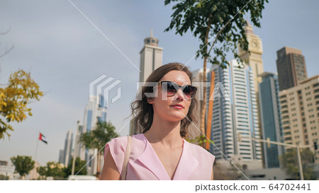 A beautiful young woman is walking in the center of Dubai. A beautiful young woman is walking in the center of Dubai. 64702441