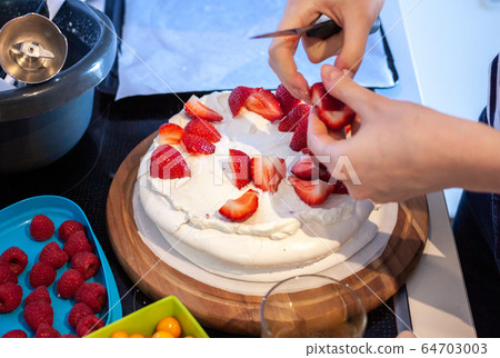 preparing pavlova cake at home female hands 64703003