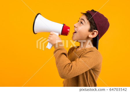 attractive european boy shouting news in a megaphone for a poster on an orange studio background 64703542