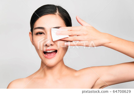 young beautiful asian woman with clean and bright skin, Cosmetic Beauty Concept,hands touch on the cheek, smiling and friendly face isolated on grey background young beautiful asian woman with clean and bright skin, Cosmetic Beauty Concept,hands touch on the cheek, smiling and friendly face isolated on grey background 64708629