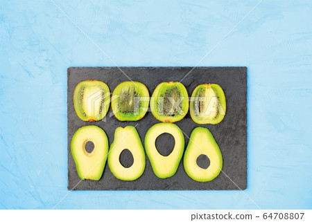 Sliced avocado and kiwi slices on a gray cutting 64708807