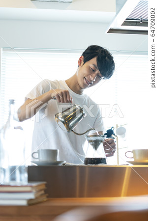 Young men making coffee 64709002