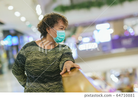 Old asian woman in a mask for COVID-19, for protection against the crown virus. Asian senior woman with protective mask because dirty air smog, PM2.5. Coronavirus old woman walking with surgical mask Old asian woman in a mask for COVID-19, for protection against the crown virus. Asian senior woman with protective mask because dirty air smog, PM2.5. Coronavirus old woman walking with surgical mask 64710881