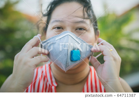 Asian woman hold mask in hand for COVID-19, for protection against the crown virus.  64711387