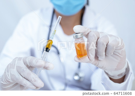 The doctor's hand holding yellow serum tube and The doctor's hand holding yellow serum tube and 64711608