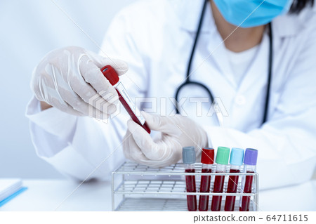 Doctor hand holding blood tube and recording the 64711615