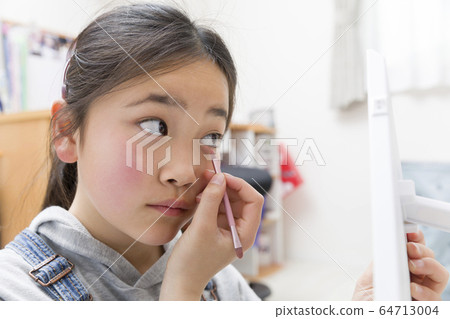 Elementary school girl practicing makeup at home Elementary school girl practicing makeup at home 64713004