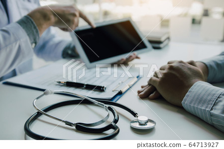 Asian doctor talking the patient at clinic while 64713927