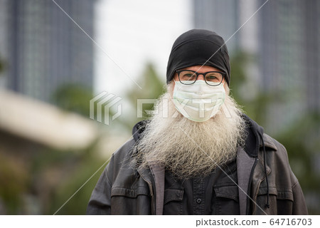 Face of mature bearded hipster man with mask for protection from corona virus outbreak 64716703