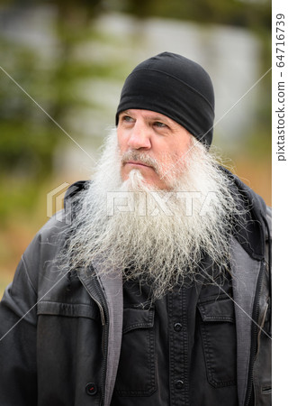 Face of mature bearded hipster man with hat thinking 64716739