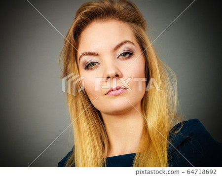Portrait blonde young woman having serious face Portrait blonde young woman having serious face 64718692
