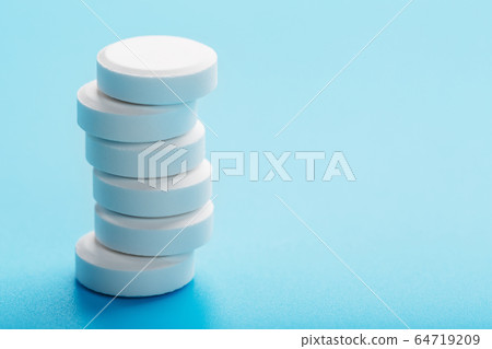 Round medicinal pills tower on a blue background, 64719209