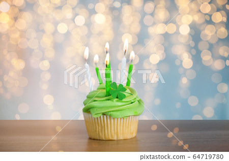 green cupcake with six burning candles on table green cupcake with six burning candles on table 64719780