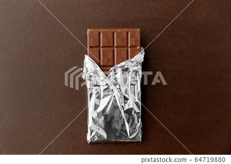 chocolate bar in foil wrapper on brown background 64719880